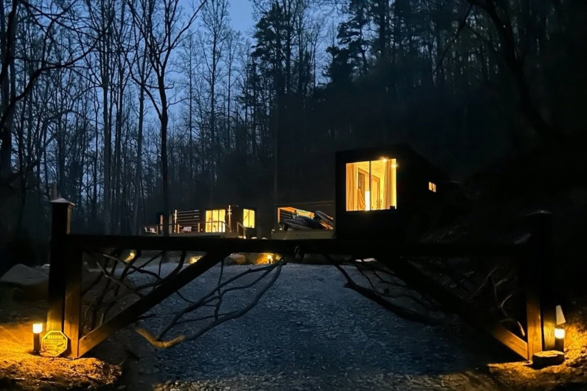 Modern cabin on stilts illuminated at twilight in a forest setting, embodying the healing power of Mother Nature.